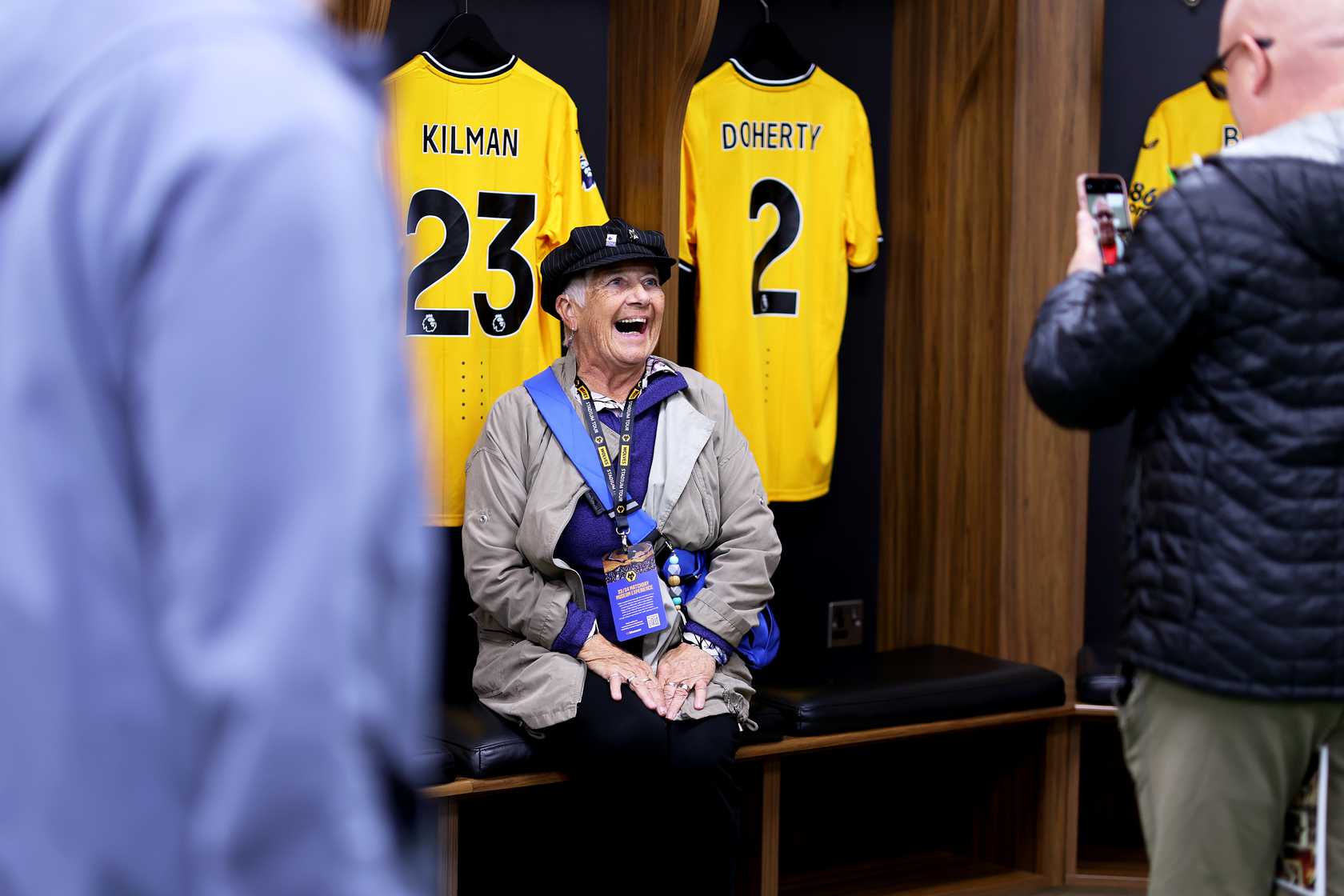 Lady smiling sat in the Wolves changing rooms whilst on a Molineux Stadium Tour